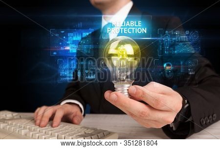 Businessman holding lightbulb with RELIABLE PROTECTION inscription, online security idea concept