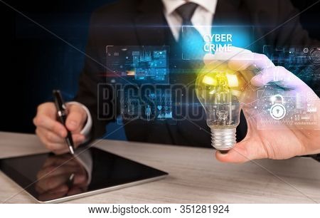 Businessman holding lightbulb with CYBER CRIME inscription, online security idea concept
