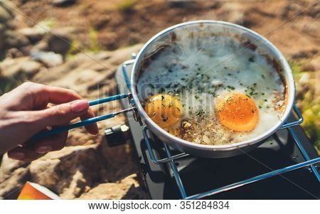 Person Cooking Fried Eggs In Nature Camping Outdoor, Cooker Prepare Scrambled Omelette Breakfast Pic
