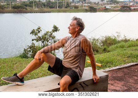 Senior Man Relaxing After Working Out At A Fitness Park