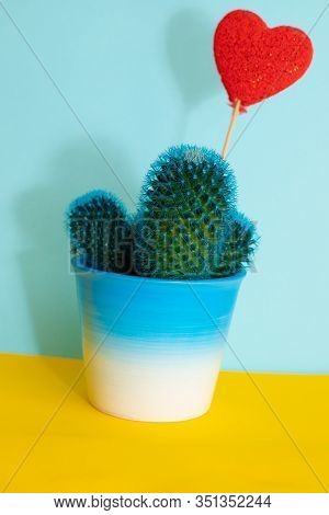Little Turquoise Cactus On A Blue Background With Heart Candy. Copy Space. Houseplants Concept.
