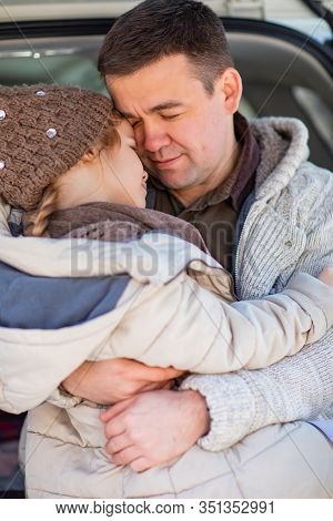A Daughters In A Hat Is With Father In Winter Clothes. Love In The Family.