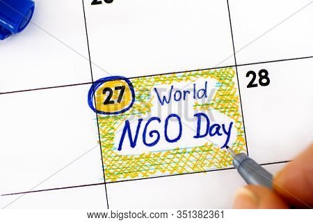 Woman Fingers With Pen Writing Reminder World Ngo Day In Calendar. February 27.