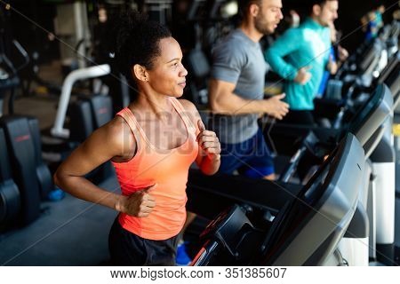Group Of Young People Running On Treadmills In Sport Gym