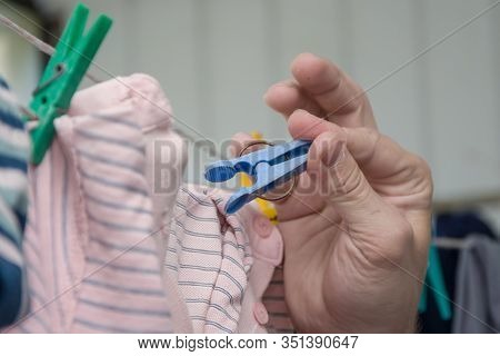 Portrait Of A Man About 30 Years Old With A Beard, Hangs His Clothes On A Clothesline, Leads A Bache
