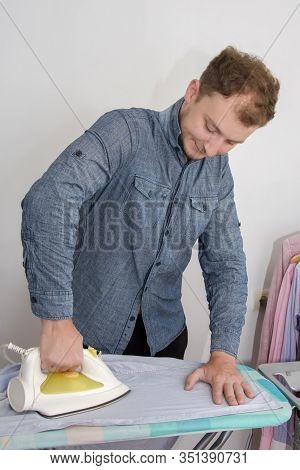 A Man Of About 30 Years Irons His Clothes With An Iron, Leads A Bachelor Lifestyle, Is Going To Visi