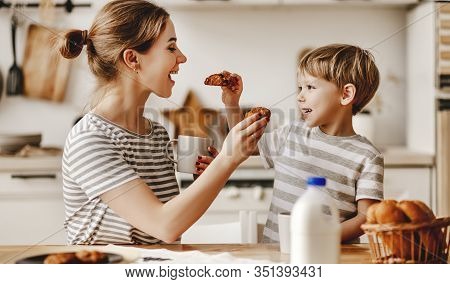 Preparation Of A Family Breakfast. Mother And Child Son Cut Bread And Eat Cookies With Milk In Morni