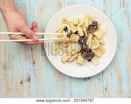 Man Eating Spicy Chinese Or Korean Yuba Tofu Bamboo And Oyster Mushrooms On Wooden Background.
