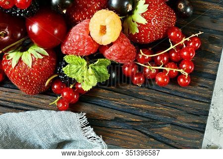 Summer Berries On A Wooden Board Close-up. Berry Fruits Like Strawberries, Blueberries, Red Currants