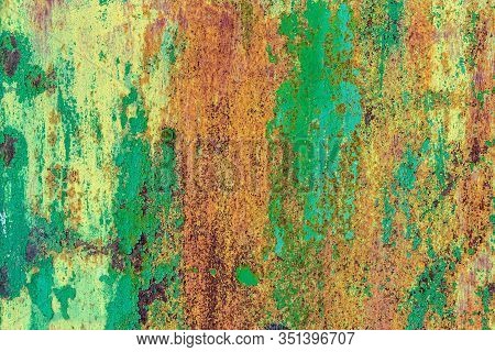 Part Of Old Metal Exterior Doors. Yellow And Green Painted, In Bouncing Layers,  Rusty Surface With 