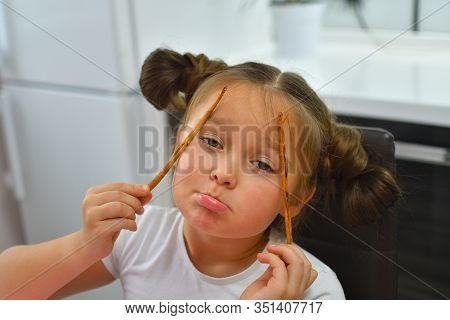 Cinnamon Concept. Girl Grimacing With Cinnamon Sticks. Girl Holding And Smelling Cinnamon Stic. Port