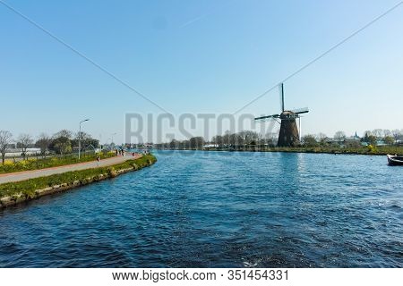 Waterways And Canals In North Holland With Boats And View On Traditional Dutch Mill, Spring Landscap