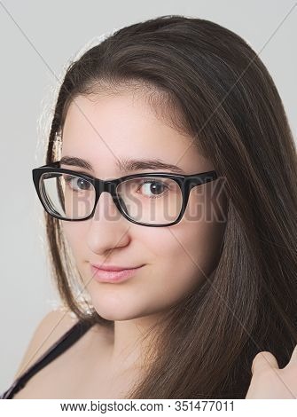 Portrait Of A Smiling Bespectacled Long-haired Brunette Teen Girl