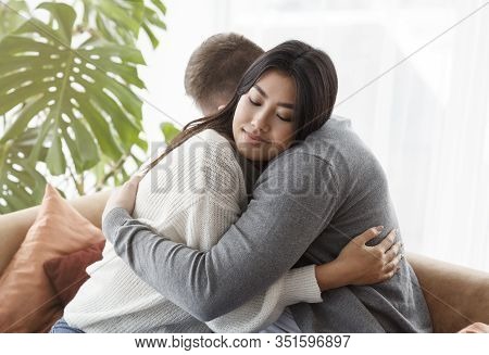 Family Reconciliation. Loving Spouses Hugging After Effective Couple Therapy Sitting In Psychologist