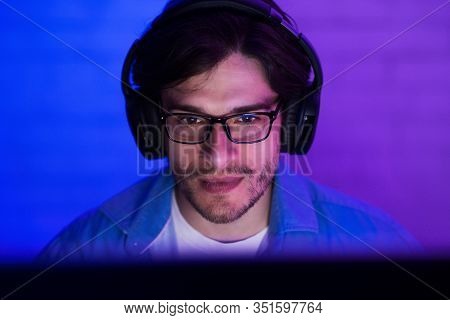 Pro Gamer Portrait. Guy At Desktop Pc Playing Computer Game Sitting Indoor At Night. Online Gaming. 
