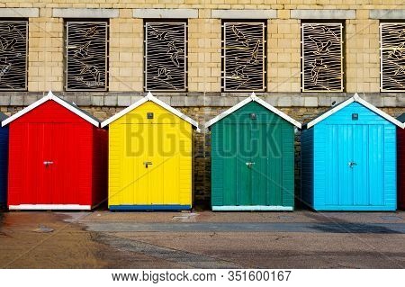 Boscombe, Dorset, England-january 13,2015: A Row Of Colorful Beach Huts Nestle Below The Honeycombe 