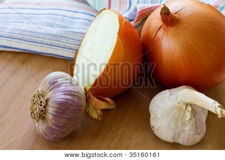 einige Zwiebeln und Knoblauch auf Holzbrett