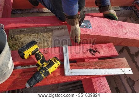 Workers Mount Wooden Beams For The Roof.