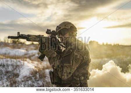 Equipped Army Soldier Man In The Winter Khaki Camouflage Is Patrolling Or Patrol Field Territory. Co
