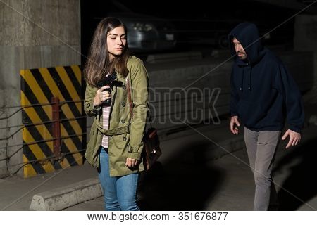 Young Latin Woman With Gun Prepared To Fightback Against Bandit Following Her In Dark Alley