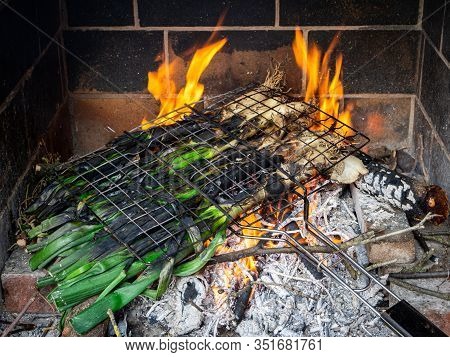 Bunch Of Calcots (typical Winter Scallion Or Green Onions From Catalonia) Being Cooked In A Barbecue