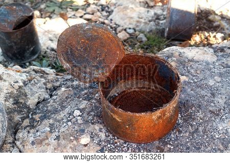Open Old Rusty Tin Cans Covered With Ash On Rock. Concept Of Environmental Pollution, Ecological Pro