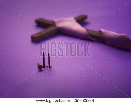 Good Friday, Lent Season And Holy Week Concept - Three Rusty Nails And A Christian Cross  On Purple 