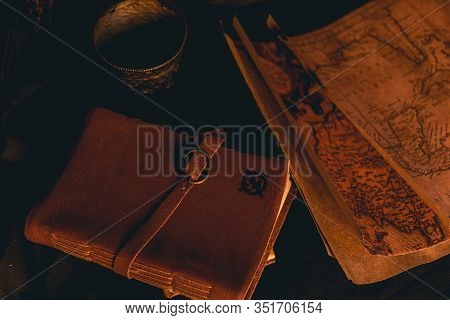 Old Plans Next To Other Elements In The Light Of Candles In Rustic Wood