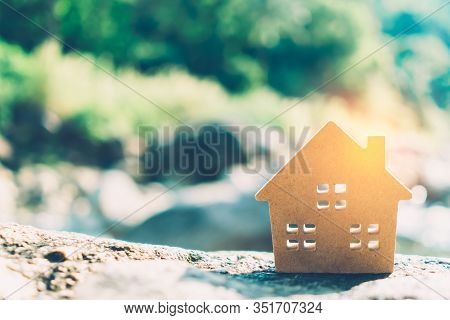Closed Up Tiny Home Model On Floor Or Wood Board With Sunlight Green Bokeh Background. Deam Life Hav