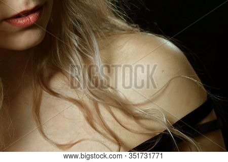 Seductive Sexy Girl Bared Her Shoulder. Close-up. Female Naked Shoulder And Hair On A Black Backgrou