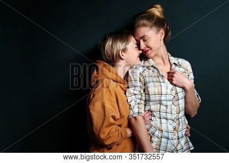 Portrait Of Young Gay Couple, Lesbian Women Hugging On Black Background With Copy Space. Сoncept Of 