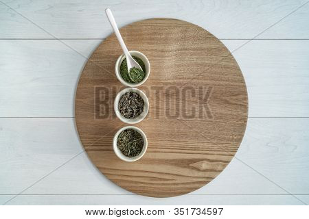 Tea leaves chinese loose leaf selection top view of table with teacups for drink tasting on wooden tray. Green matcha, royal white peony, butterfly jasmine from Fujian province.