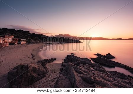 Long Exposure Image Of Sun Setting Over The Golden Sand Of Plage De Sainte Restitude Beach In The Ba