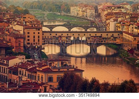 View From The River To The Famous Italian Medieval Bridge - Ponte Vecchio In Florence On Sunset, Tra