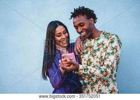 African Couple Watching Videos On Smartphone - Young People Having Fun Shopping Online With New Tren