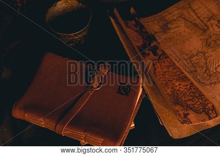 Old Plans Next To Other Elements In The Light Of Candles In Rustic Wood