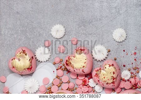 Pink Hearts From Tempered Chocolate With Chocolate Drops, Meringues And Dried Berries On Grey Backgr