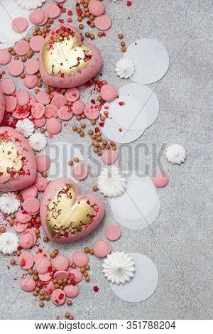 Pink Hearts From Tempered Chocolate With Chocolate Drops, Meringues And Dried Berries On Grey Backgr