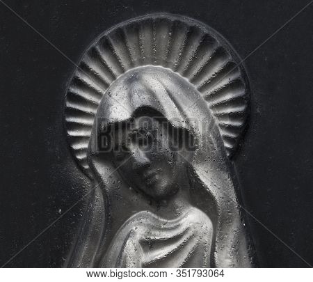 Bas-relief Virgin Maria On Dark Vintage  Background.