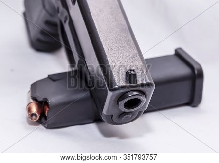 A Black 9mm Pistol With A Pistol Magazine Loaded With 9mm Hollow Point Bullets On A White Background