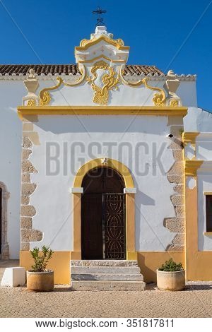 Entrance To Igreja Matriz De Alvor - Church In A Portuguese City. White Facade With Yellow Details. 