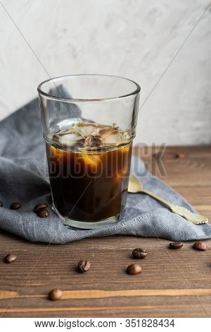 Iced Black Coffee Beans On Wooden Background