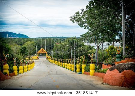 Entrance To Wat Lined With Statues On Yellow Pedestals In Pak Nam Pran, Pranburi Thailand
