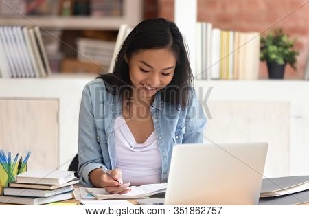 Attractive Smiling Asian Woman Student Studying With Books And Laptop