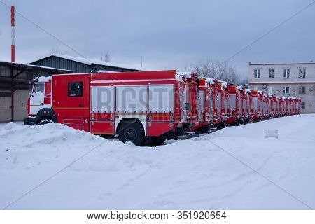 Many Fire Engines Stand In The Snow Ready To Leave. Fully Equipped Fire Engines. Profile And Rear Vi