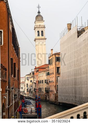 Venice, Italy - 02 05 2020: Canal With Boats In Venice (italy) In Winter, Leaning Bell Tower Of San 