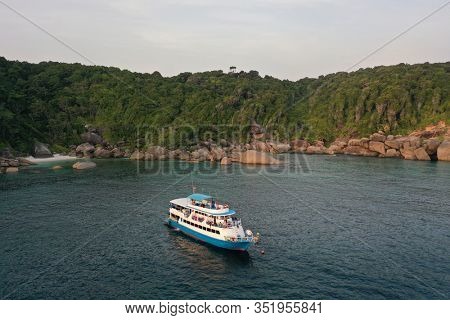 Scuba diving liveaboard boat beside tropical island 