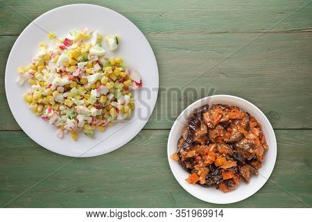 Crab Salad On A White Plate With Vegetarion Salad. Crabs Salad On A Green Wooden Background Top View