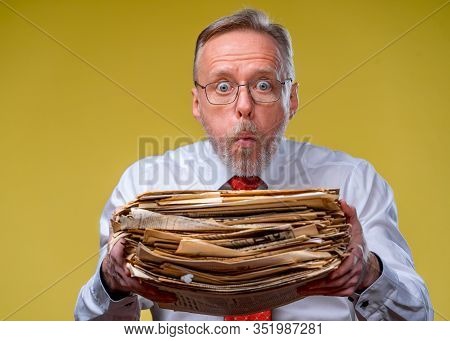 Pile Of Documents In Hands. Senior Man Holdind Piles Of Documents Paper Work. Surprised Of Hard Ment