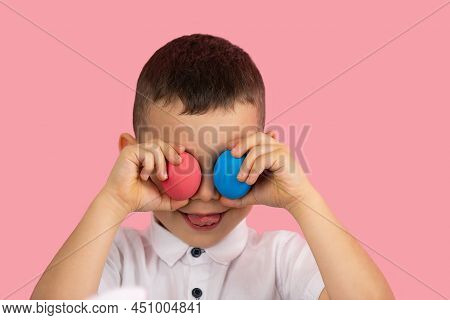 Little Boy In White T-shirt Covering His Eyas With Two Egg Red And Blue Color And Showing Tongue Pos